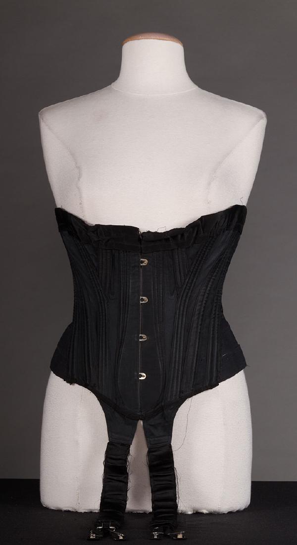BLACK SATIN CORSET, c. 1900: black silk boned corset w/ CF garters, W 34", Underbust 43", CF 11.5", (new gussets added, wear on garters); very good