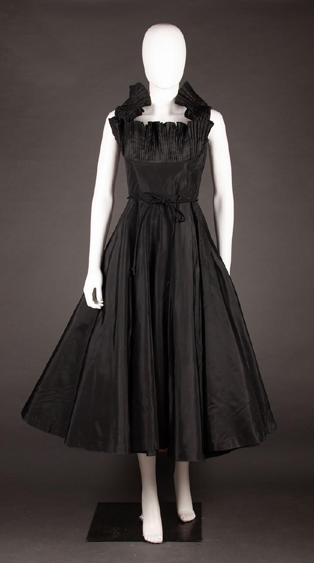 DRAMATIC CEIL CHAPMAN PARTY DRESS, 1950s: Black rayon faille, accordion pleated standup ruff around neckline, wider at back where it falls away from body, cord tie belt, labeled, B 32", W 24", L 47", (light underarm stains, right underarm men