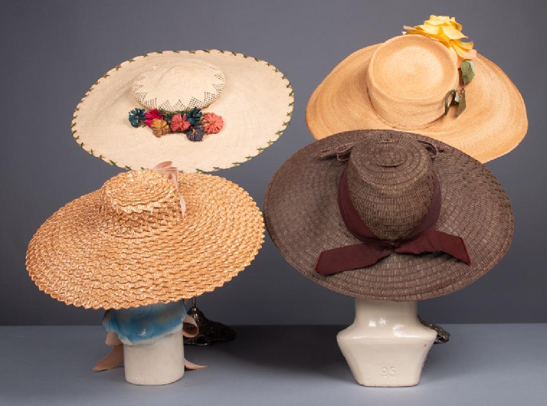 FOUR WIDE BRIM STRAW HATS, 1940s: 2 tan straw: 1 w/ pink ribbon, (ribbon dirty w/ stain at 1 end) & 1 w/ yellow flower trim, (3.25" stain to CF brim, missing ribbon at crown) both very good; 1 cream w/ raffia blossoms & 1 brown w/ cho
