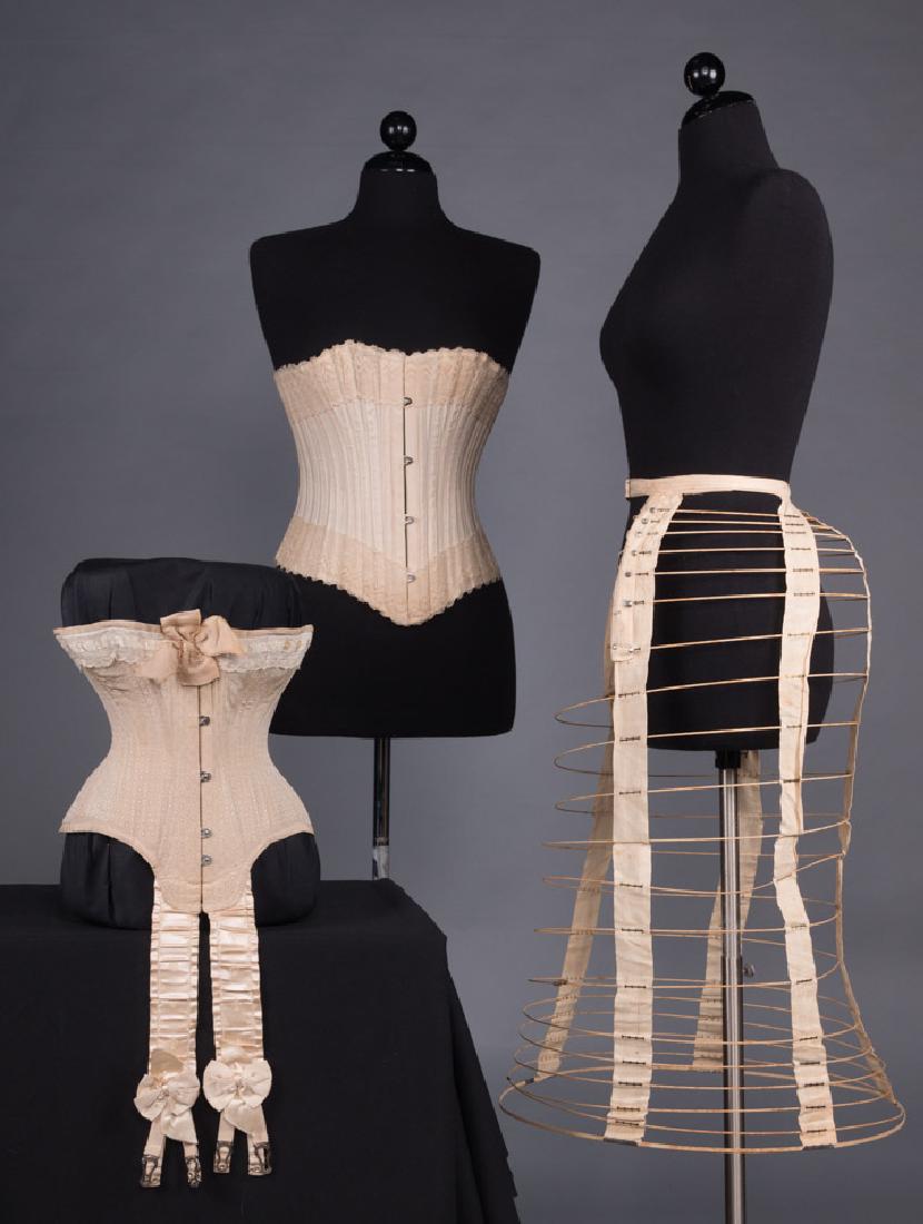 TWO CORSETS & ONE BUSTLE CAGE, 1870-1890s: 1 wire & cotton tape bustle, L 30", (tapes stained & W tape frayed) very good; 2 cream cotton strapless corsets w/ lace trim & back lacing: 1 w/ embroidered cups & B, B 38", W 32", CF L 13", "R & G , 