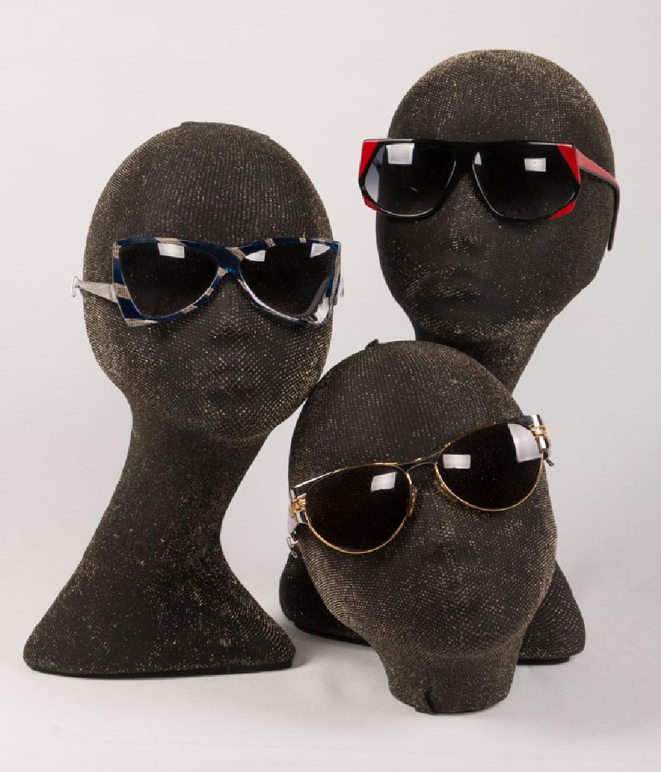 THREE PAIR DESIGNER SUNGLASSES, 1980s: 2 pair "Yves Saint Laurent": 1 pair blue & silver mesh & 1 pair black w/ red accents; 1 pair "Laura Biagiotti" w/ gold accent & tortoise temples. Museum at FIT.