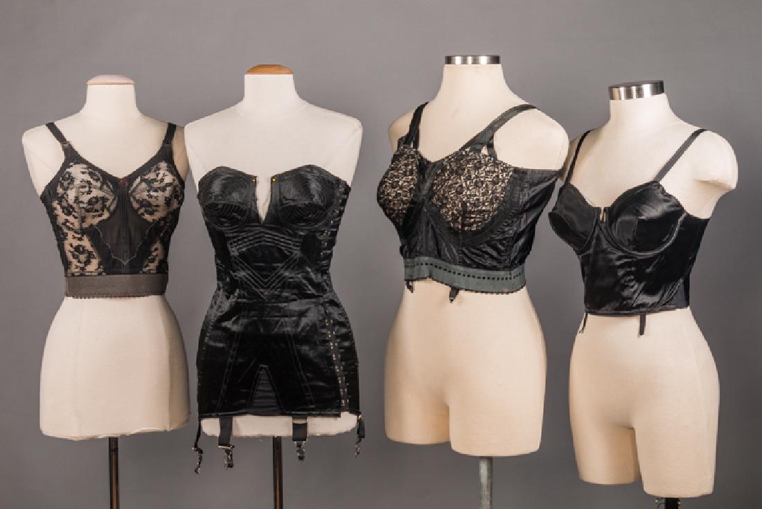 FOUR BLACK LINGERIE FOUNDATIONS, 1950s: 1 deadstock satin corset w/ side laces, (CF tear between B) poor; 3 long line bras: 1 deadstock "Simone Perele, Paris", pristine & 2 w/ lace cup inserts, (1 w/ small fade to strap) both excellent, B 3