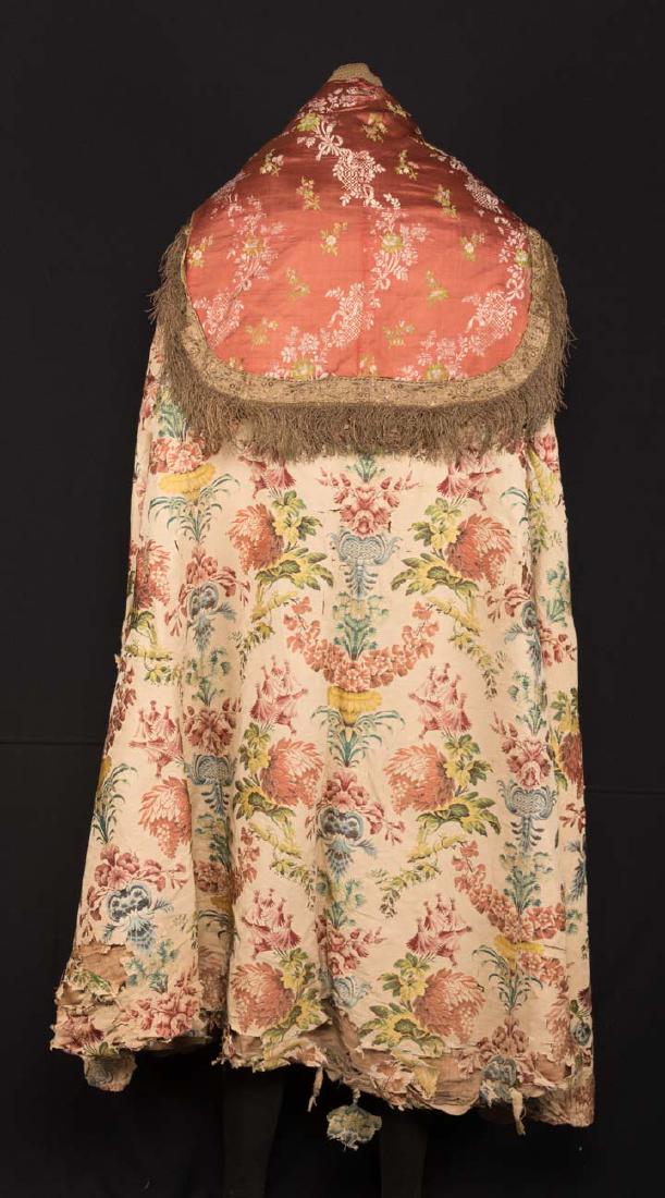 SILK BROCADE COPE, 18TH C: White silk w/ blue, peach & green brocade in large pattern w/ peach, white & green brocade back collar w/ metallic gold fringe, 2 front panels in blue & peach brocade, WD 112", L at CF 57", (back pane