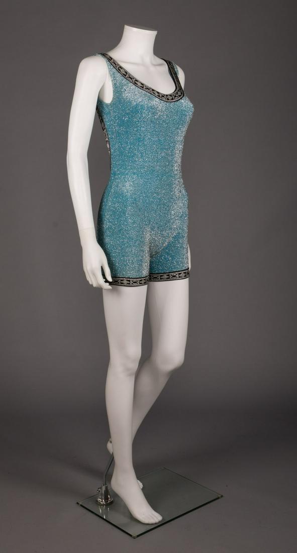 PIERRE CARDIN LUREX KNIT SWIM SUIT, 1960s: Aquamarine & silver lurex bathing romper w/ black & silver trim, scoop neck to skinny straps & low scoop back, label "Pierre Cardin", B 34", W 24", H 34", L 31", (some pulls at right H) very good.