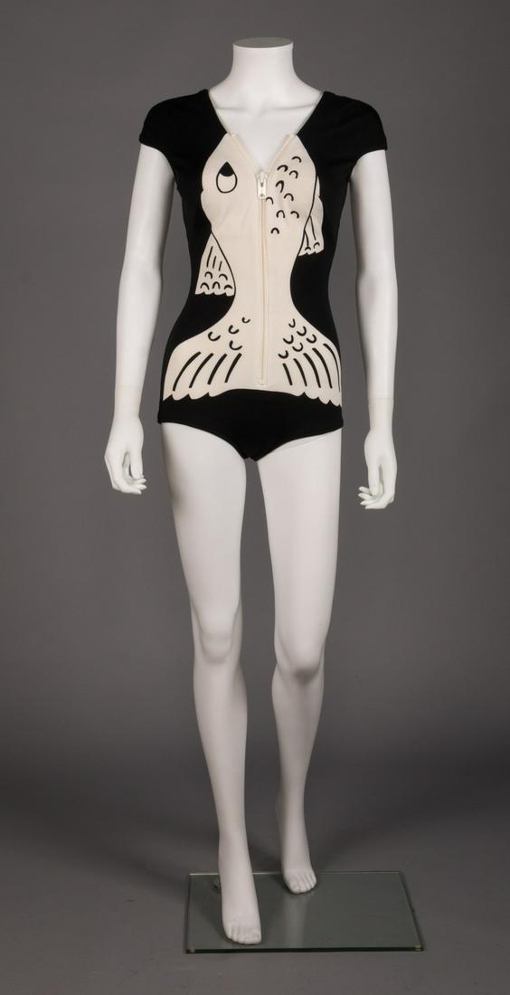 GEOFFREY BEENE FISH SWIM SUIT, JUNE 1963- APRIL 1964: Early Geoffrey Beene black & white bathing suit, graphic fish front w/ zipper as mouth, cap sleeve to scoop back w/ built in lace bra, label "Geoffrey Beene for Roxanne", B 34", W 24", H 34", L 26", e