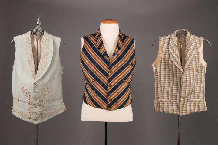 THREE MENS VESTS, MID 19TH C: 3 mens mid 1800s waistcoats w/ 3 slit pockets: 1 light blue silk faille embroidered w/ red & grey bud & vine motif, c. 1850, CH 36", L 24", (dirty at closure) very good & 1 of tan, blue & green cotton