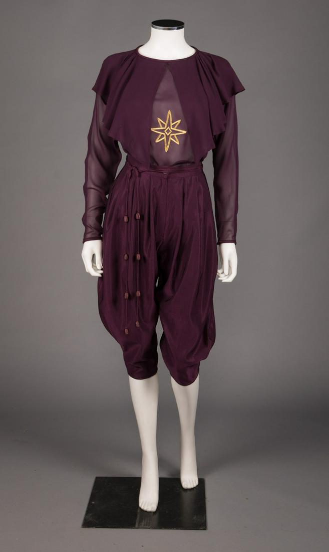 GIANNI VERSACE THREE PIECE JODHPUR ENSEMBLE, AW 1981: 3-pc ensemble in royal purple w/ gold flecks c/o silk chiffon long sleeve blouse w/ gold star embroidered at CF & caped front detail, high W silk wool faille jodhpurs w/ side slit pockets & corded & b