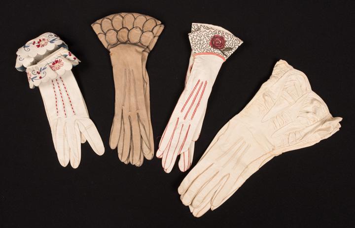 FOUR PAIR LADIES GAUNTLET GLOVES, 1930s: 1 blue & red on white w/ embroidered roll over cuff, 1 sand colored w/ petalled gauntlet, 1 red & white w/ rose motif & white w/ ruching (all w/ mild dirt to pads) all very good- good.