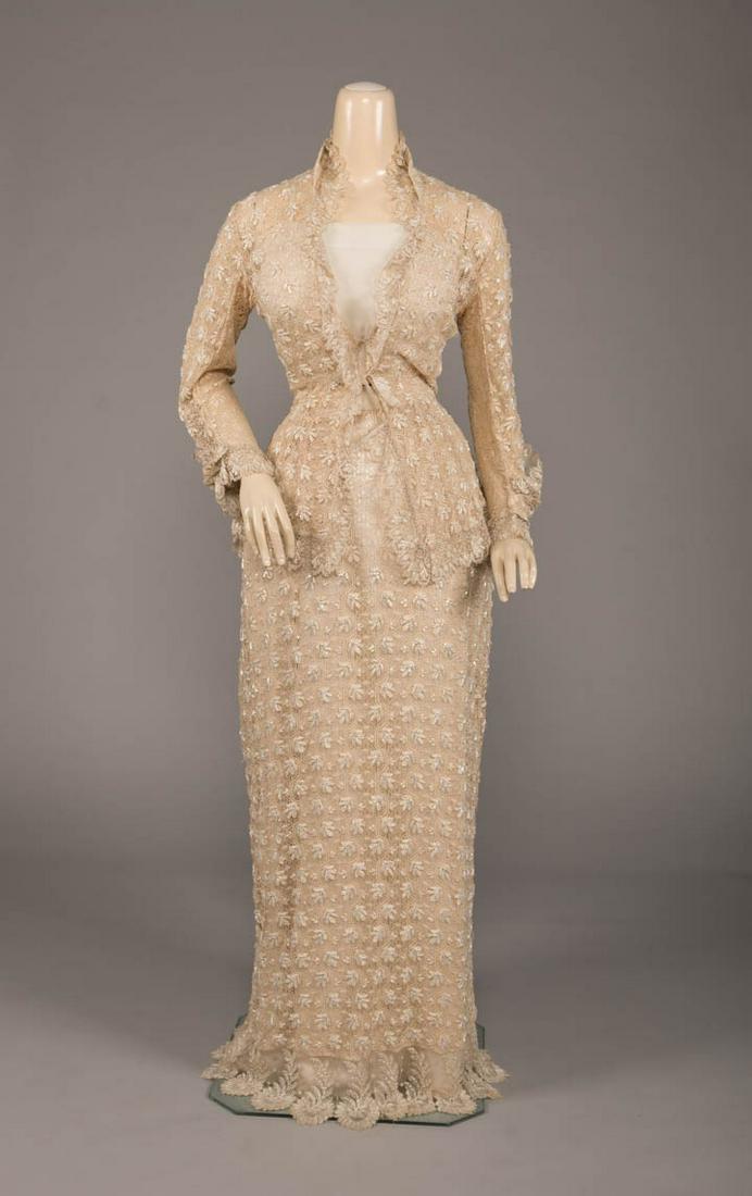 EMBROIDERED & BEADED OVERGOWN, 1880s: 2-pc overgown in woven silk lace embroidered w/ Czech chatoyant bugle beads, long sleeved princess bodice w/ silk ribbon tie closure, shaped cuff drape, overskirt w/ CB closure to draped & scalloped b