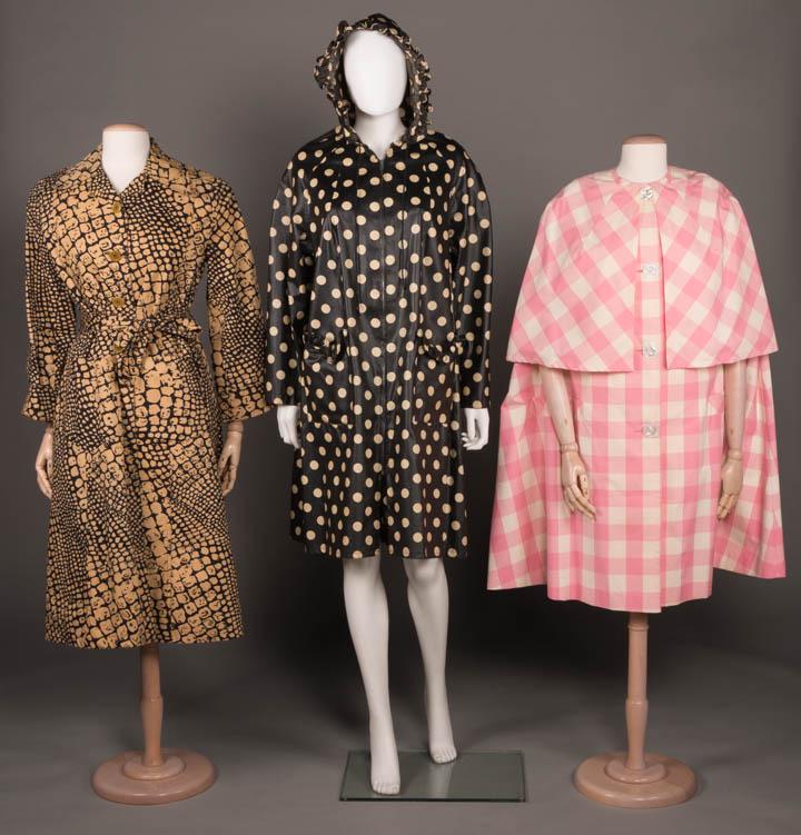 THREE RAINCOATS, AMERICA, 1965-1977: 1 cotton tan & black stylized alligator print w/ self tie belt, turnback cuffs, single box pleat from SH yoke to W & double box pleat below W, 2 oversized patch pockets, CF button closure, notched cap