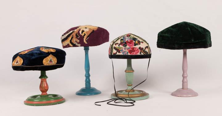 FOUR MENS HATS, CENTRAL ASIA, 20TH C: 1 blue cap w/ gold metallic laid-work, heart shaped motif w/ red & green velvet centers edged w/ silver Turkish embroidery, black velvet brim, corded quilted interior, circumference 21.5", size 6 7/8,