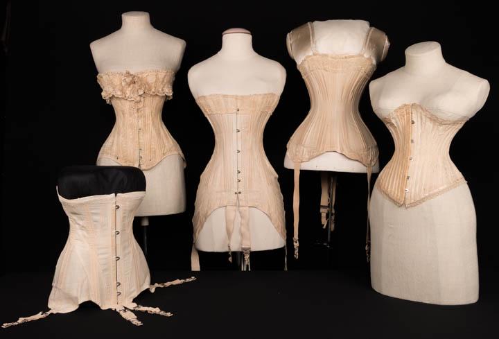 FIVE CORSETS, 1895-1910s: 1 patterned silk w/ wide band of mm Val lace & ribbon edging, 1895-1900, (silk shattering, bones exposed, repairs, holes in lace); 1 cotton drill w/ B & H godets w/ hose fasteners, 1900-1910, (trim wo