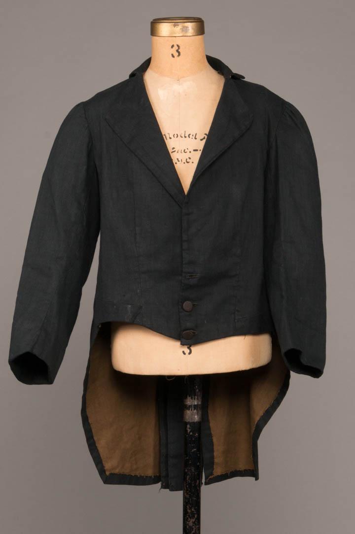 BOY'S TAILCOAT & BREECHES, 1840-1870s: 1 black cotton w/ black basket weave covered buttons, flatlined in brown cotton, 1860s, C 30", L 15.5-25", (missing 1 button, stain at CF W, left underarm seam opening) very good; 1 blue & white cotto