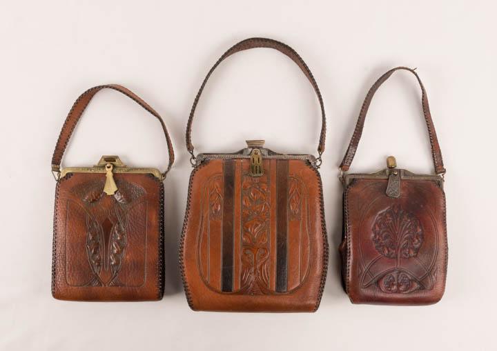 THREE ART NOUVEAU TOOLED PURSES, AMERICA, 1915-1918: 1 w/ 2-tone leather & tooled stylized floral, matching coinpurse, keeper lock clasp, lined in grey suede, stamped w/ patent "May 15th 1917 & July 23rd, 1918" 6.5" x 9" x 2";1 w/ Lily of the Valley bou
