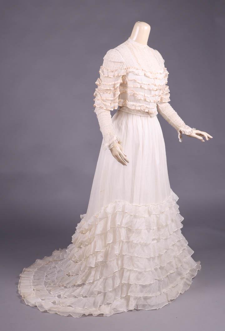 LINGERIE GOWN, c. 1907: 2-pc cotton lawn lingerie gown, bodice yoke w/ vertical ruching & lace inserts at front, back, SH caps & lower fitted sleeve, tiered double ruffle edged w/ cream silk ribbon layered over panel to fron