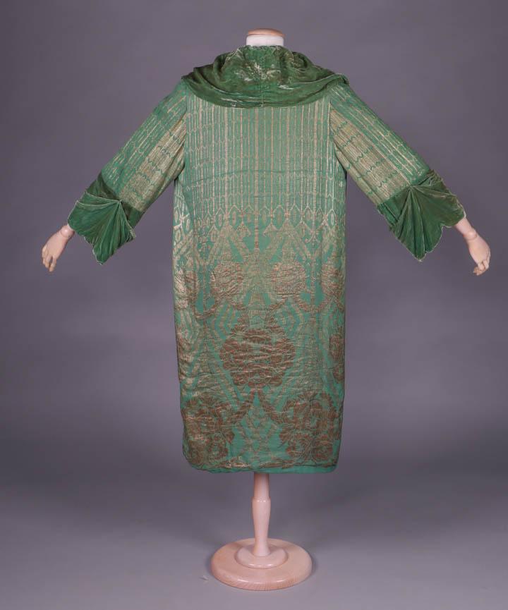 SILK VELVET & LAMÉ EVENING COAT, c. 1918: Emerald green silk velvet evening coat w/ gold lamé rose, swag & pseudo gothic motif, velvet front gathered panels to cowl neck & gathered, draped velvet cuff, entirely lined in moss green silk velve