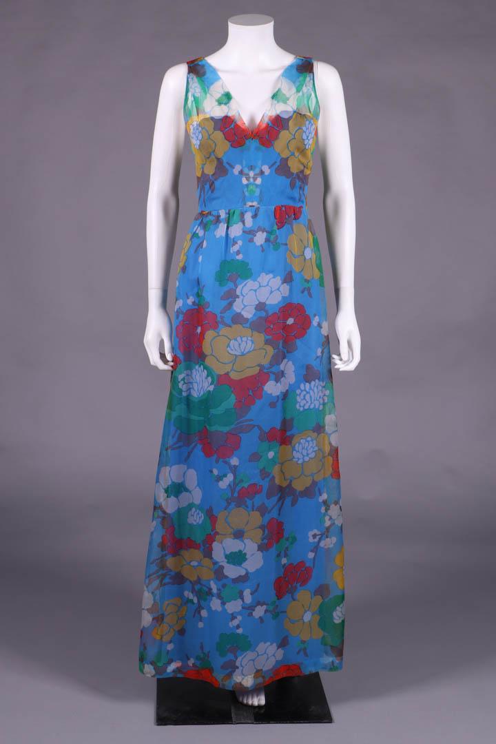 GIVENCHY FLORAL CHIFFON PARTY DRESS, PARIS, 1973: Silk georgette sleeveless floor length dress in Japanese woodcut inspired florals including branches of white cherry blossoms on blue ground, w/ plunging V-neck to mirror motif piecing at CF seam, jum