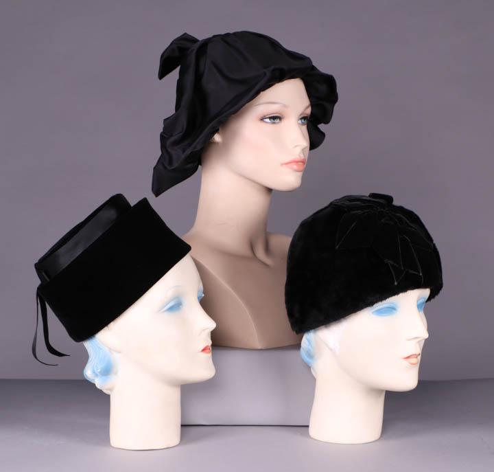THREE BLACK DIOR HATS, 1950-1960s: 1 silk velvet pillbox set w/ top tier wrapped w/ black double faced satin ribbon to flat bow at CB w/ 2 cascading ribbon tails, label "Christian Dior, New York Inc.", circumference 21", size 6 5/8, (s