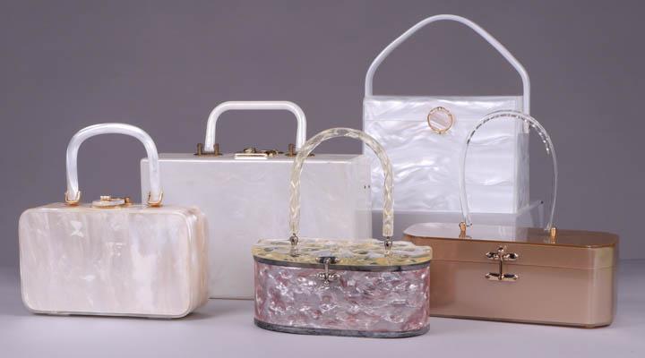 FIVE LUCITE HANDBAGS, AMERICA, 1950s: 1 cream pearlescent, label "Walberg", 8.75” x 2.5" x 9", (ghosting on back & bottom, missing 1 foot, lining stained, gilding worn); 1 large pearlized white w/ lock, 11" x 3" x 9.5", (wear to gilding
