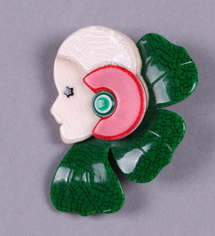 SEVEN LEA STEIN ART DECO BROOCHES, PARIS, MODERN: All stamped on findings "Lea Stein, Paris": 3 Corolle Flower Lady brooch, all w/ striped ivory colored face & black star eye, 1 w/ teal & black stone motif collar & cap, white snakeskin shell ear, 1 w