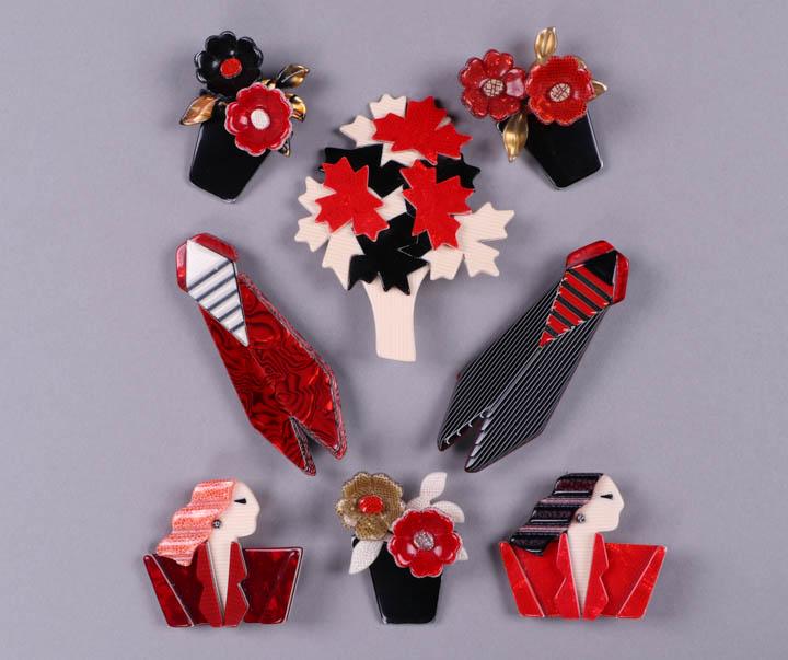 EIGHT BLACK, RED & WHITE LEA STEIN BROOCHES, PARIS: All modern & stamped on findings "Lea Stein, Paris”: 2 Carmen Joan Crawford both w/ ivory striped figures, black eyes & B&W ball earrings, 1 w/ cherry red snakeskin blazer & black & purple cobblesto
