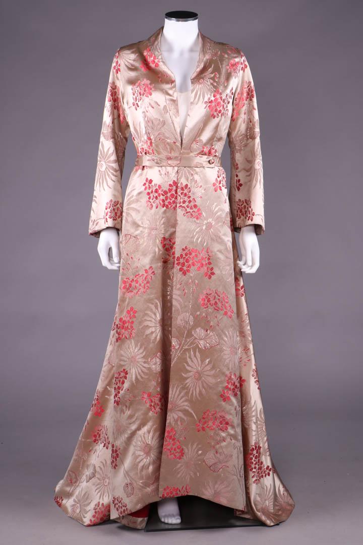 SILK & LAMÉ DRESSING GOWN, 1930s: Trained dressing gown in geranium & ox eye daisy red, pink & lamé pattern on silk satin ground, small shawl collar, open CF to W, narrow cross over tab front belt w/ 2 self-covered dome buttons, 1930