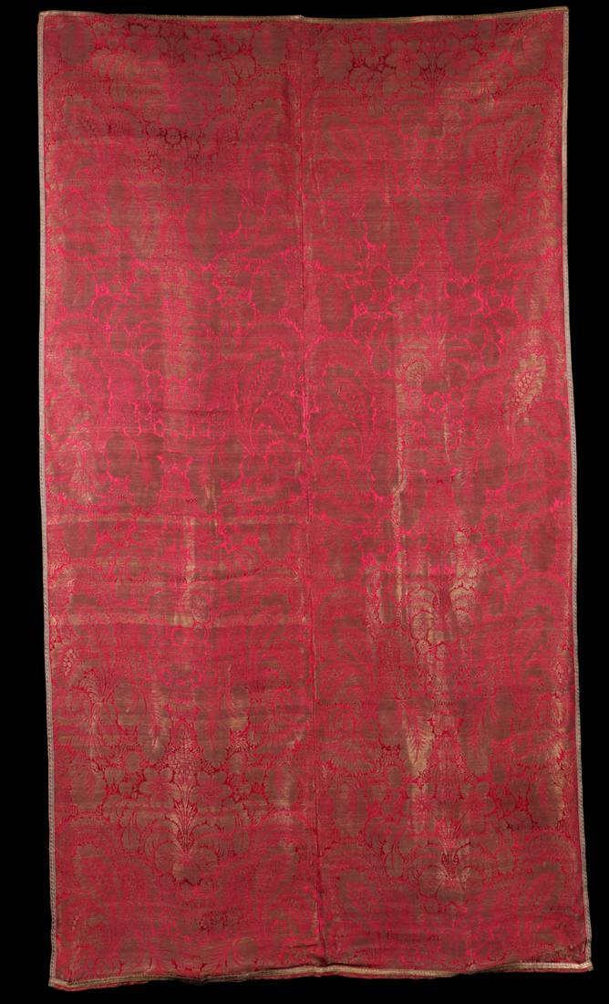 ORNAMENT D'EGLISE PANEL, c. 1700: Gold metallic weft in ornament d'eglise w/ flowers & foliate on red silk satin ground, metallic warp threads on selvage, backed in red silk taffeta, edged w/ gold galloon, 42.25" x 76", (stains & tiny