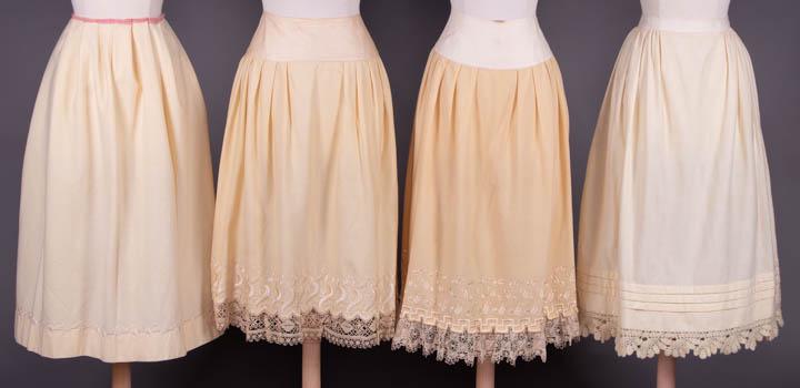 FOUR DECORATIVE WINTER PETTICOATS, 1870s: 1 wool & cashmere w/ Heilmann embroidered floral sprays & imitation cutwork over hem, circ. 76", L 31", (unpicked W band, spot stains throughout) good; 2 wool trousseau petticoats w/ silk Schiffli emb
