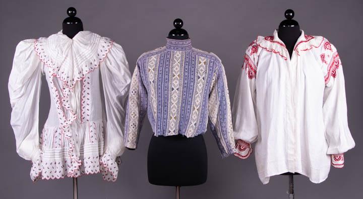 THREE REGIONAL BLOUSES, 1890-1920: 1 folk inspired bodice w/ machine embroidered red & blue buds to collar & peplum, c. 1890, B 45", W 33", L 30", (tiny dark stain above W, pull to fabric right arm, 0.75" light stain B ruffle) good; 1
