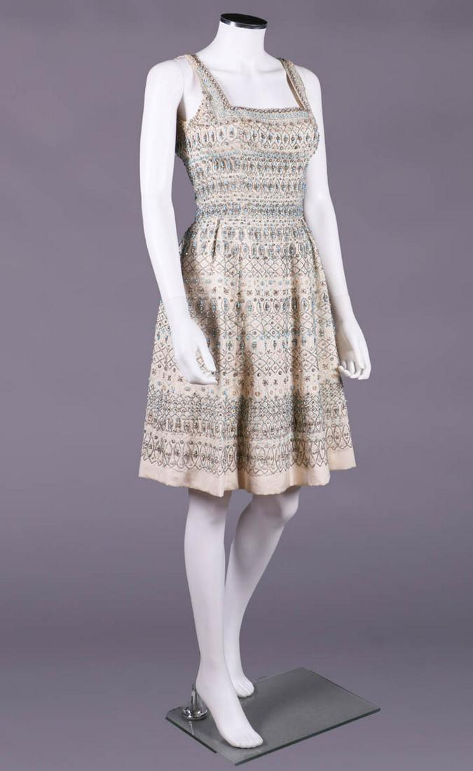 PEDRO RODRIGUEZ COUTURE BEADED COCKTAIL DRESS, SPAIN: Ivory silk faille dress w/ square neckline based on 16th C high fashion portraits, sleeveless, fitted bodice w/ princess seaming to flared skirt pleated over Hs, encrusted in horizontal beaded bands o