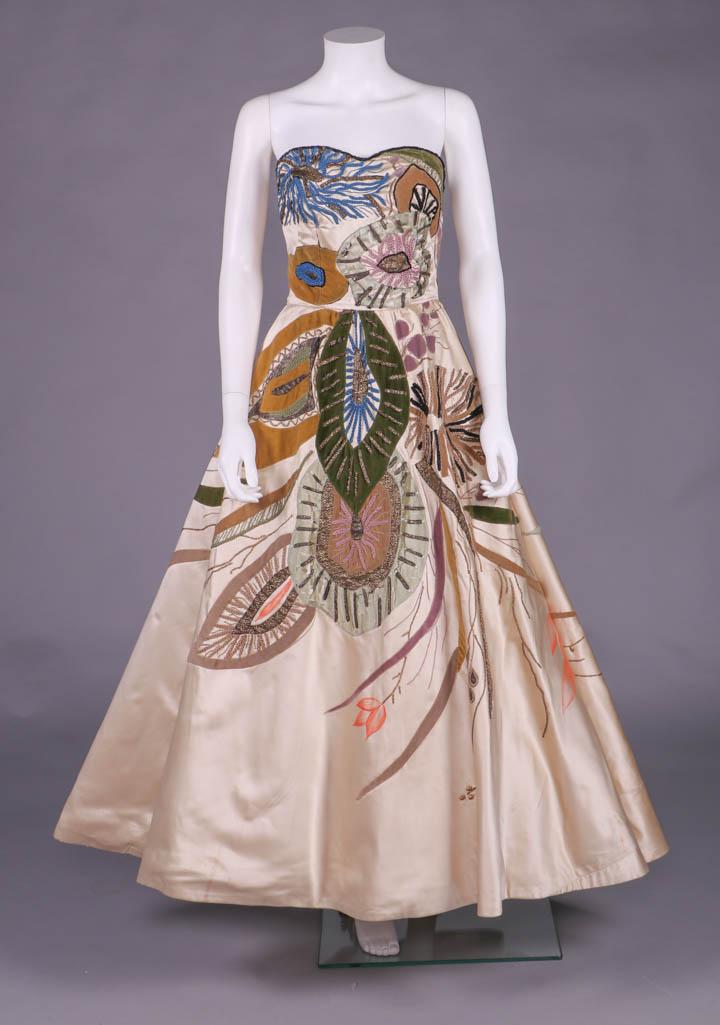 EMILIO SCHUBERTH EVENING GOWN, ROME, c. 1950: Cream silk satin strapless evening gown w/ surrealist aquatic biologically inspired velvet appliqués in pink, blue, mustard & moss green heavily embroidered in silk & metallic braid, hand painted cor