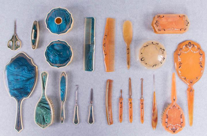 TWO LUCITE OR BAKELITE DRESSING SETS, 1930s: 1 Bakelite set, items ranging in size 4"-13": 1 glass jar w/ bakelite lid, (lid scuffed); 1 rectangular box, (velvet faded, hinge detached); 1 large comb, (paint worn); 1 small comb, (chipped, tines w