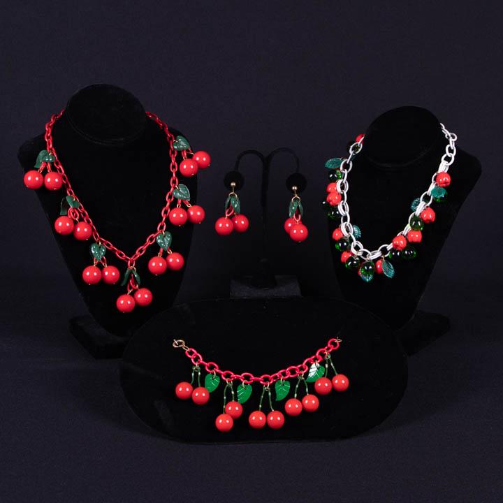 CELLULOID CHERRY DEMI PARURE, EARLY-MID 20TH C: Set c/o necklace, earrings & bracelet in cherry motif w/ paired carved leaves: 1 cherry necklace, circ. 20", (paint on leaves lightly worn, light scratches); 1 cherry bracelet, circ. 8.25", (cherry st