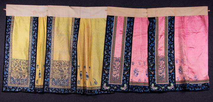 TWO PAIRED MANDARIN SKIRTS, CHINA, LATE 19TH-EARLY 20TH: 1 yellow CF & CB panels rendered entirely in Peking knot w/ architectural & dragon motifs over waves, blue & white ombre satin stitch embroidery in floral & butterfly motifs to borders, pleated sectio