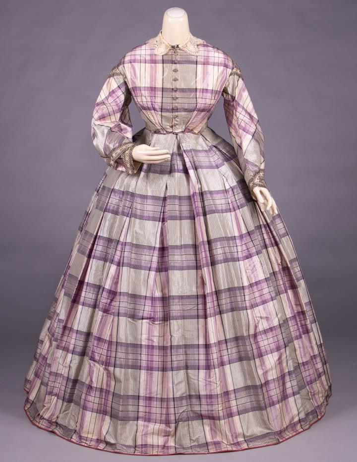 PLAID SILK TAFFETA DAY DRESS, c. 1860: 2-pc day dress in lavender, charcoal & cream silk plaid, CF thread covered gum drop button closure, 2-pc military sleeve w/ multicolor floral ribbon trim edged w/ black & tan looped cording, broderie 
