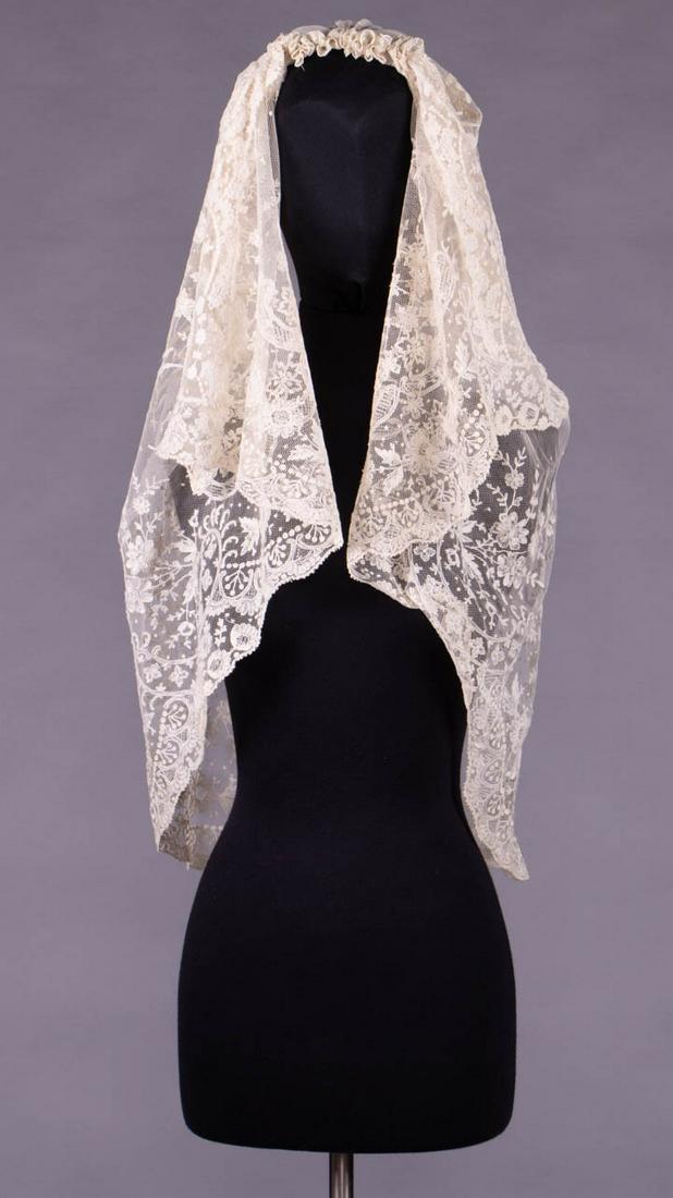 ANTEBELLUM EMBROIDERED WEDDING VEIL, 1850s: 1 shaped veil in cream Tambour, running stitch & drawn net work in Baroque revival & floral motifs, 64.5" x 39", (tiny holes in top of head, probably reshaped at edges) very good.