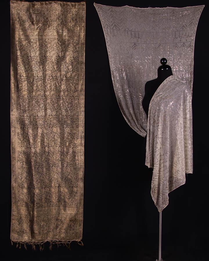TWO METALLIC EMBELLISHED SHAWLS, EGYPT & INDIA: 1 ivory & silver metallic assuit shawl, 1920s, 36.5" x 95", (metal tarnish, cluster of holes, 1.25" hole near edge) fair; 1 gold lamé & silk brocade Benaras type shawl w/ boteh containing tiger, elep