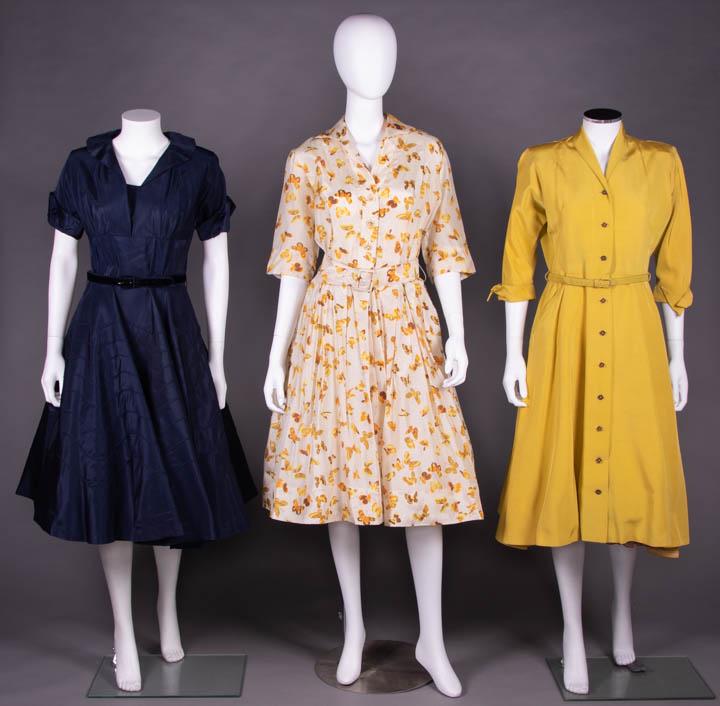 THREE FIT & FLARE DAY DRESSES, AMERICA, 1950s: 1 midnight navy day dress w/ pleated collar, short SLV, turn back cuff w/ small velvet bows, velvet belt, full skirt w/ inset cording in undulating wave pattern, B 44.5", W 28", L 44", (light stain CF