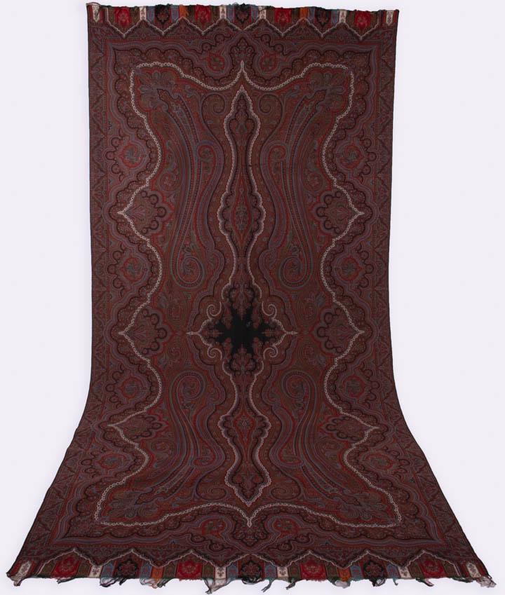WOVEN PAISLEY SHAWL, FRANCE, c. 1867: Paisley w/ architectural border & tracery motif w/ undulating botehs & geometric patterns, symmetrical on both axis, 63.5” x 131.5" w/ 3" fringe, (messy fringe, light wear, few tiny-0.5" holes) 