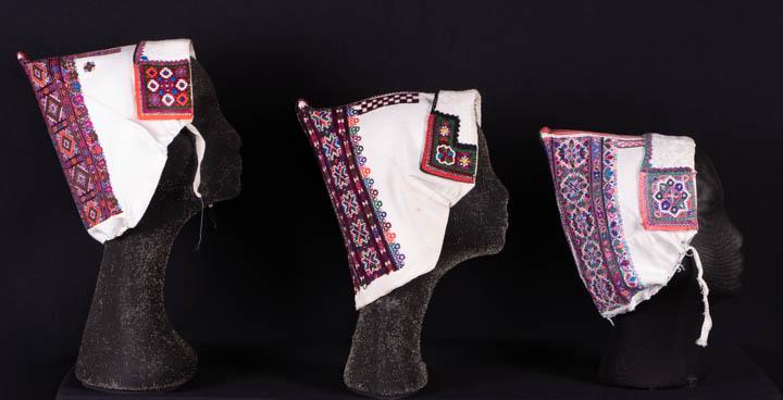 3 EMBROIDERED FOLK BONNETS, ZAVADKA SLOVAKIA, MID 20TH: 3 traditional regional bonnets hand embroidered in primary cross stitch w/ symbols, devises & patterns to indicate wearer’s social status in terms of marriage & family, CB highly embroidered & w