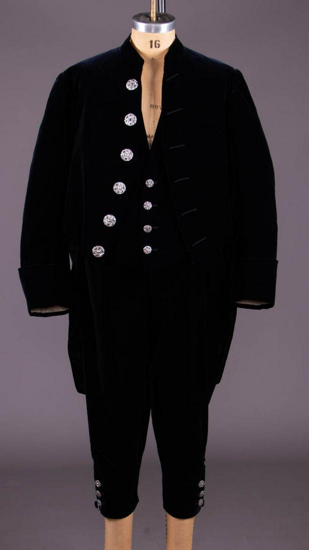 MANS THREE PIECE COURT SUIT, LONDON, C. 1916: 3-pc black velvet suit w/ marcasite buttons, twill silk lining, label "Hill Brothers, London & Paris" & “Benesford Heaton Esq.", tailcoat SH-SH 19", CH 46", L 19"-37", waistcoat CH 46.5", W 43.5