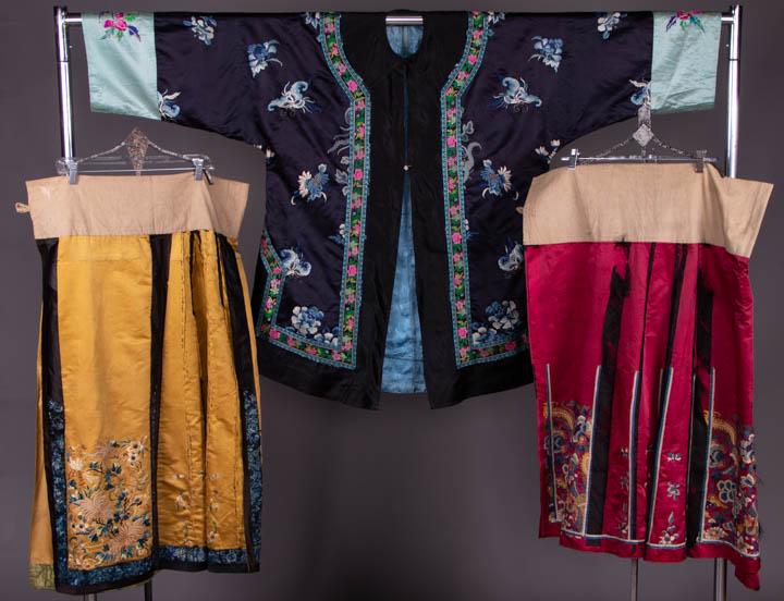 TWO MANDARIN SKIRTS & INFORMAL ROBE, LATE 19TH-MID 20TH: 1 black satin embroidered robe w/ ombre blue florals & butterflies, pink, blue & green woven ribbon applied as collar yoke & down CF, pale blue sleeves embroidered w/ florals in gilt & silk thread, si
