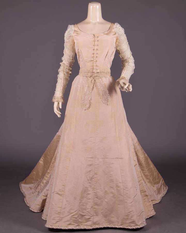SILK FAILLE EVENING GOWN, 1900-1905: 2-pc nude pink fine silk faille gown w/ round neckline, CF faux pearl button closure, ruched Renaissance crepe chiffon sleeves w/ Alençon lace cuffs, Alençon tippet W band, gored skirt w/ in