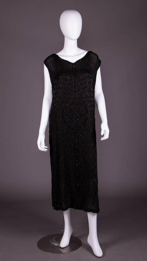 HEAVILY BEADED PARTY DRESS, LATE 1920s: Black silk georgette party dress, heavily embellished w/ bugle & faceted seed beads in overall geometric motifs w/ bands of faceted domed beads to scoop neckline, CF, CB, SS, W, & as border of seed be