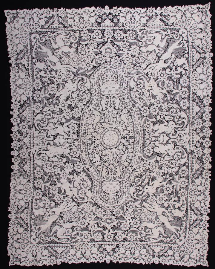 BURANO LACE TABLE COVERING, EARLY 20TH C: Handmade Burano needlelace table covering w/ florals & dancing ladies, 65" x 82", (few broken brides, two 0.25" holes to edge) excellent.