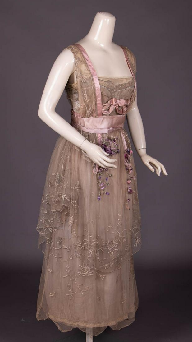 UNLABELED LUCILE EVENING DRESS OR EXCEPTIONAL COPY: Sleeveless grey silk tulle w/ machine embroidered frond, floral & bud tracery appliqued to wide SH straps & tiered skirt, pink & cream silk satin band trims w/ wrapped threadwork & couched metallic co