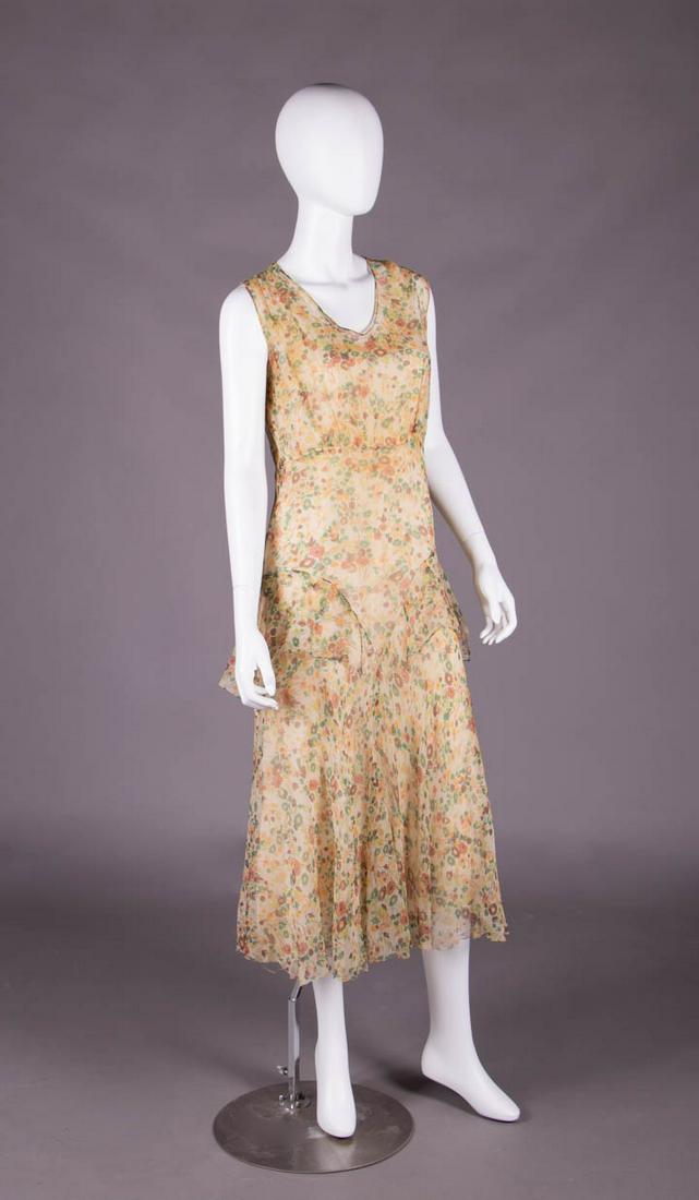 PRINTED CREPE CHIFFON AFTERNOON DRESS, 1930s: Sleeveless cream crepe chiffon printed w/ autumnal field flowers, bodice gathered below B attached to 3-pc bias cut flared skirt w/ floating inserted panels below H, B 37", W 32", L 50.5", (small runs