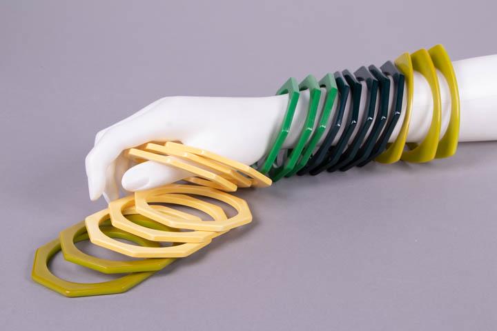 VINTAGE CELLULOID OR LUCITE GEOMETRIC BANGLES, MID 20TH: 19 bangles: 3 lime green triangular, circ. 8", Wd 0.125", (slight discoloration to edges, tiny chips); 2 lime green octagonal, circ. 8", Wd 0.25", (discoloration to edges); 3 green octagonal, circ. 8"