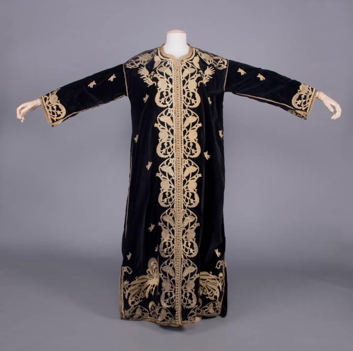 RAPPORT EMBROIDERED WEDDING ROBE, UZBEKISTAN, EARLY 20TH C: Midnight purple cotton velveteen wedding robe w/ gold metallic rapport embroidery in peacock & pheasant motif, tablet woven metallic edging w/ braided metallic button closures from below throat to hem