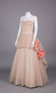 CEIL CHAPMAN EVENING GOWN, AMERICA, c. 1954: Strapless pink tulle evening gown w/ horizontally ruched fitted bodice, shaped peplum w/ self ruffle & fall w/ silk flowers in shades of peach, full floor length skirt, left SS zip closure, Rayon acet